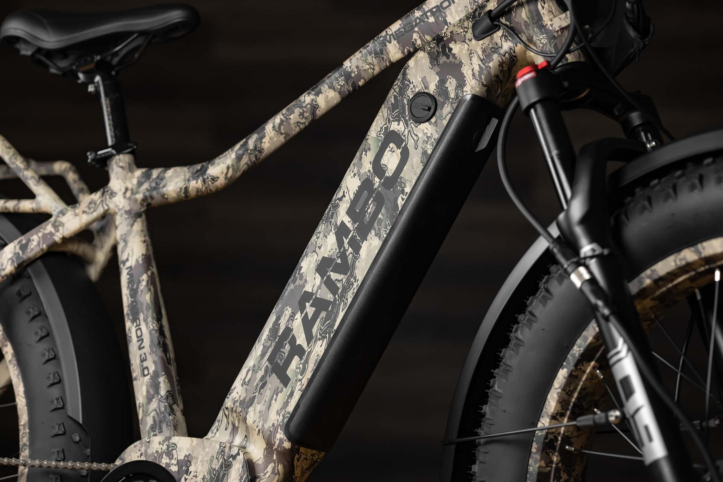 Close-up of a Rambo Bike Megatron 4.0 AWD Electric bike with a focus on the frame, front wheel and logo