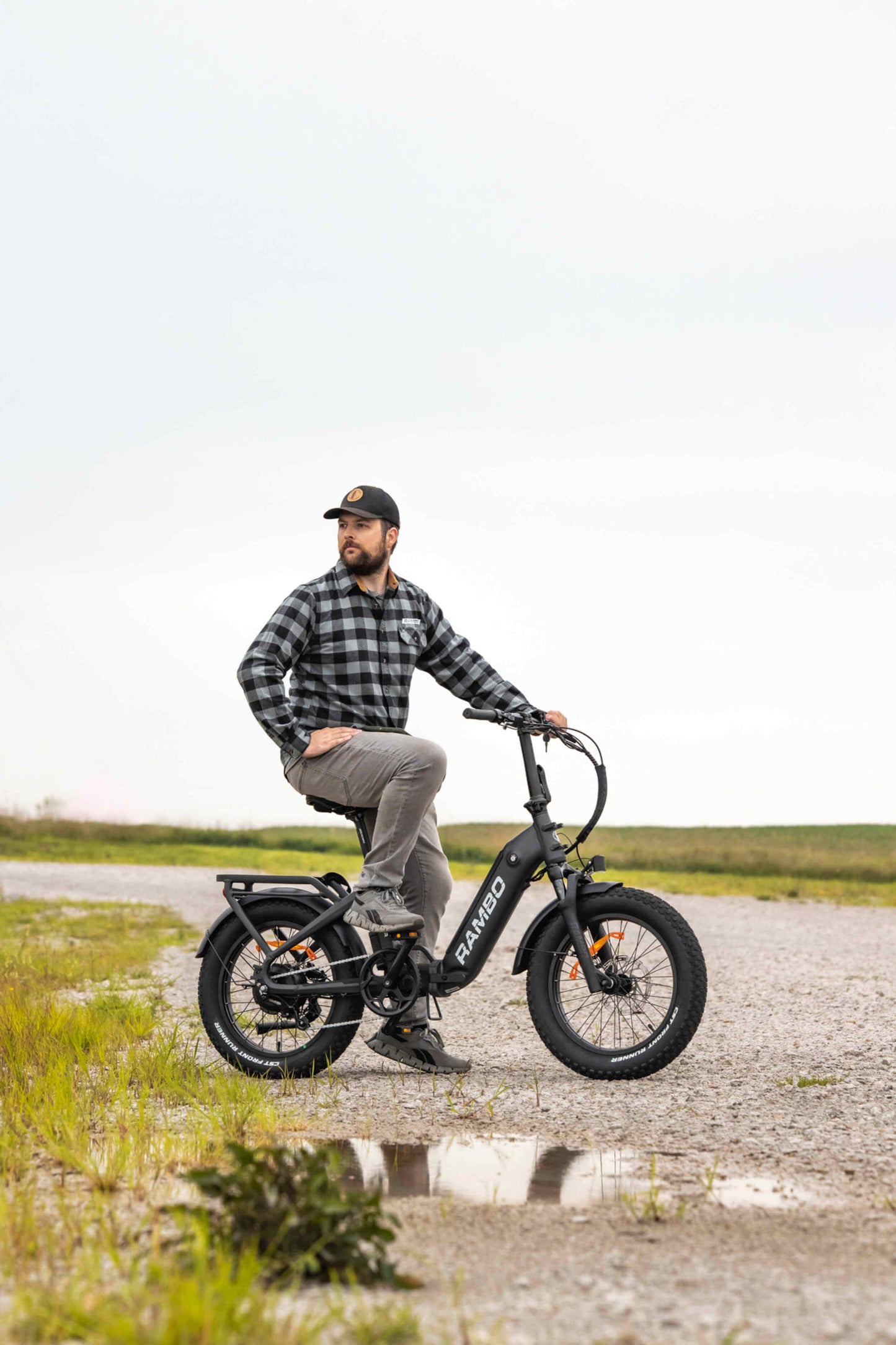 Man riding a Rambo Bikes RANGER Folding eBike on a gravel path, showcasing its rugged design and versatility.