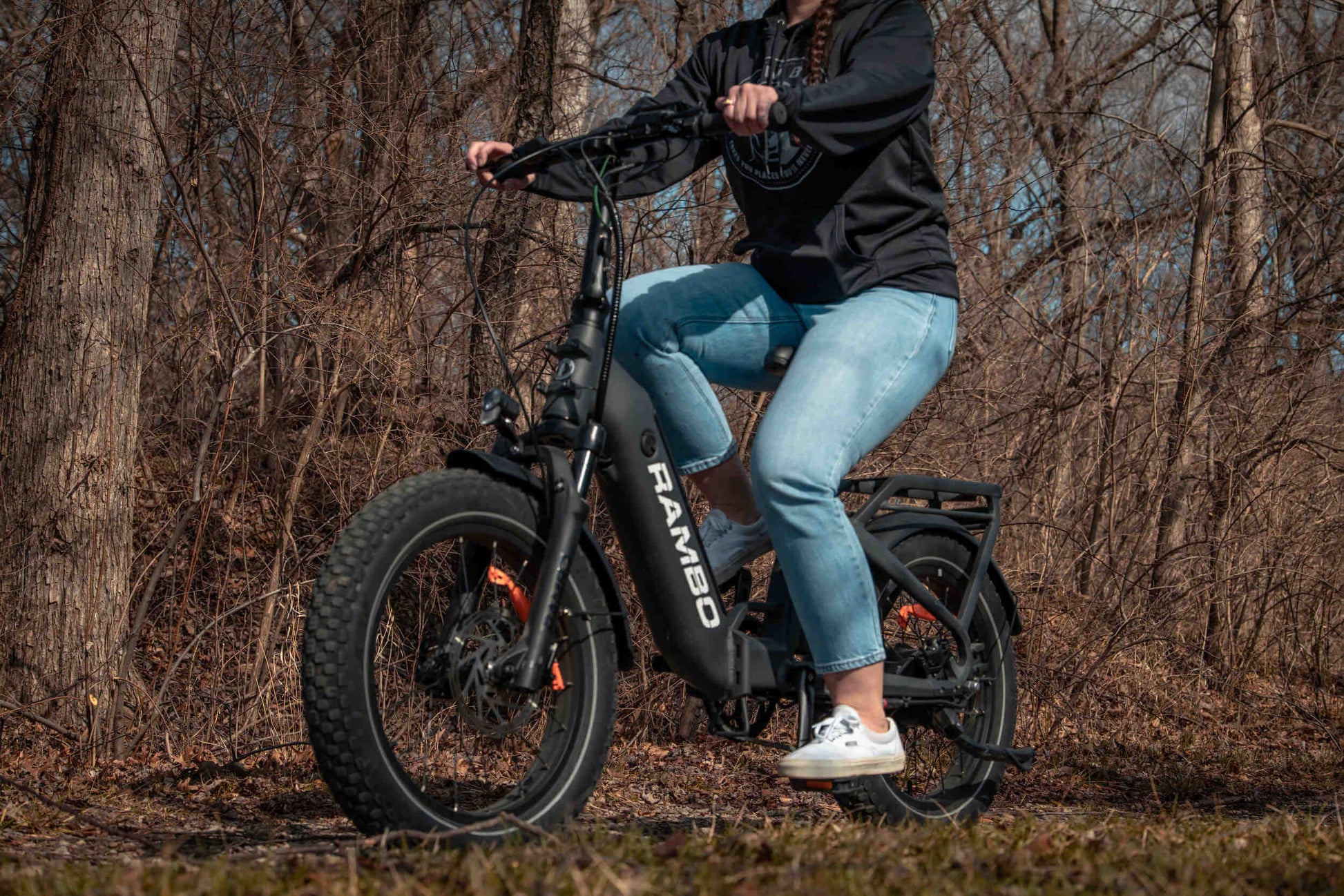 Person riding a Rambo Bikes RANGER Folding eBike on a forest trail, showcasing its durable fat-tires and sleek design.
