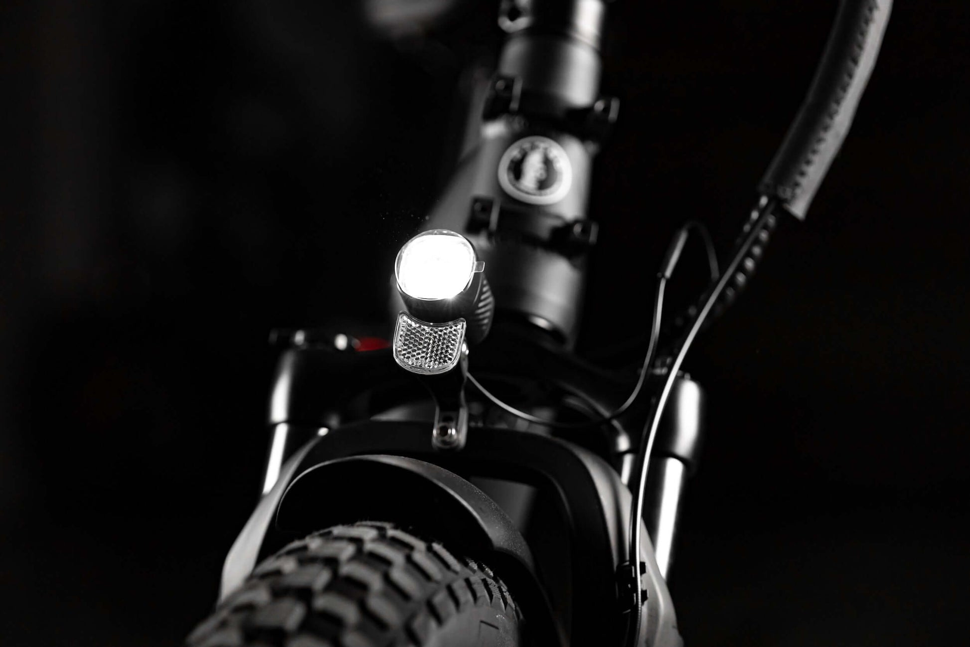 Close-up of the front light on a folding eBike, highlighting the rugged design and fat tire.