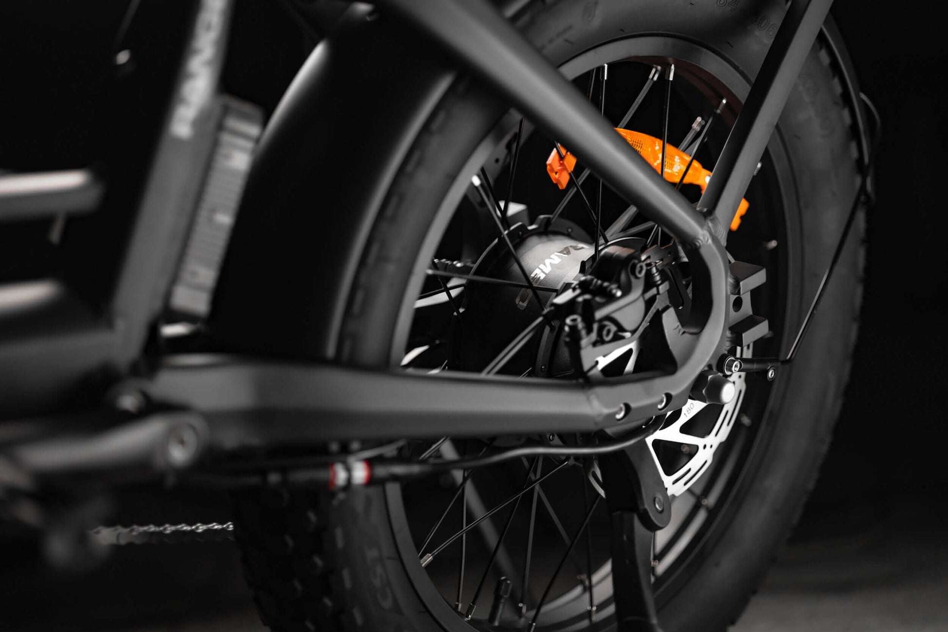Close-up of Rambo Bikes RANGER Folding eBike rear wheel, showcasing fat tire and brake components for robust performance.