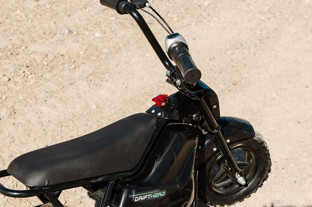Close-up of Drift Hero USA 250W Mini Electric Bikes handlebars on a gravel road