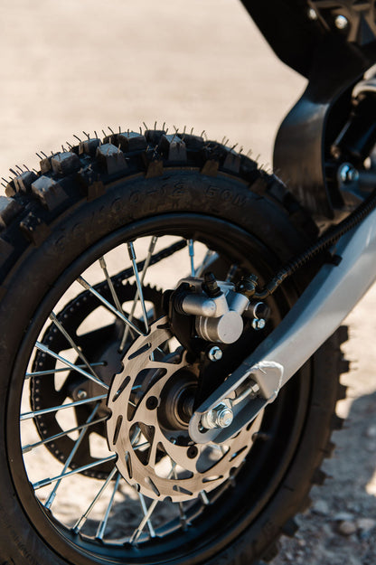 Close-up of a Drift Hero USA 2500W Electric Dirt Bike wheel with tread pattern on a blurred background