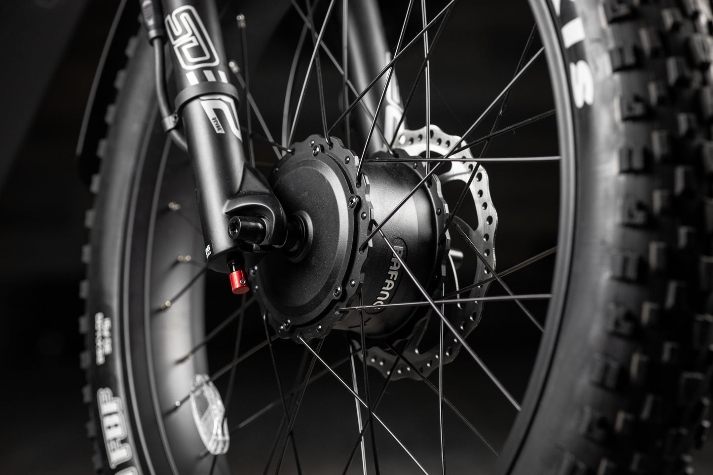 Close-up of a Rambo Bike Hellcat 2.0 AWD Electric Bikes wheel with a focus on the hub and spokes.
