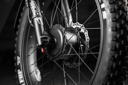 Close-up of a Rambo Bike Hellcat 2.0 AWD Electric Bikes wheel with a focus on the hub and spokes.