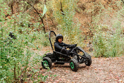 Child driving a Drift Hero USA 1 Seater Electric Go-kart through a forest