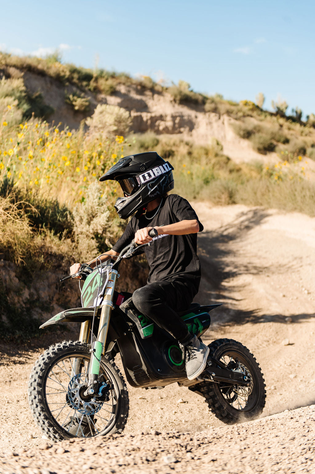 Person riding a Drift Hero USA 1600W Electric Dirt Bike on a rocky trail with a helmet and black clothing.