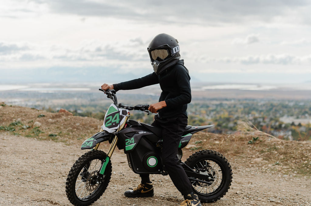 Person on a Drift Hero USA 1600W Electric Dirt Bike wearing a helmet with a scenic background