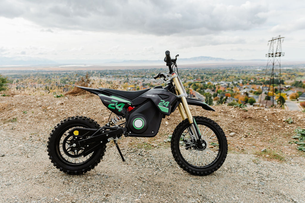 Drift Hero USA 1600W Electric Dirt Bike on a gravel hill with a cityscape in the background