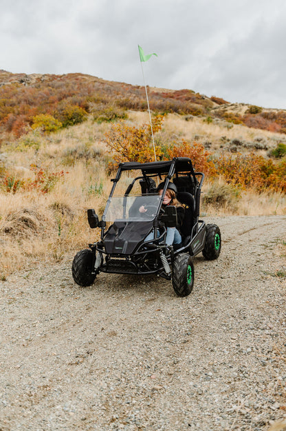 Drift Hero USA 2 Seater Electric Go-kart on a dirt path with a person inside, surrounded by a natural landscape.