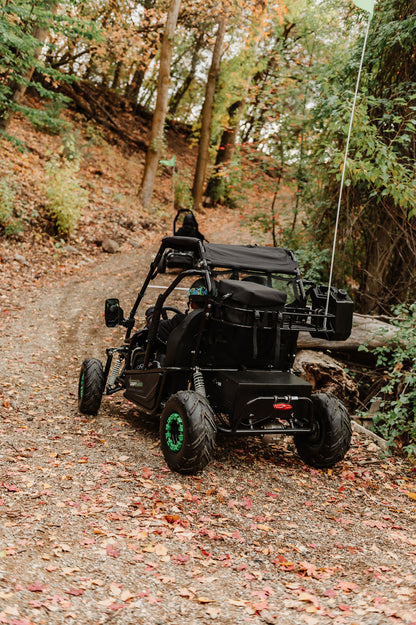 Drift Hero USA 2 Seater Electric Go-kart  on a forest trail with trees and foliage around.
