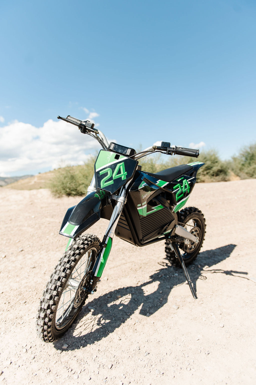 Drift Hero USA 2500W Electric Dirt Bike with number 24 on a gravel surface with a blue sky background