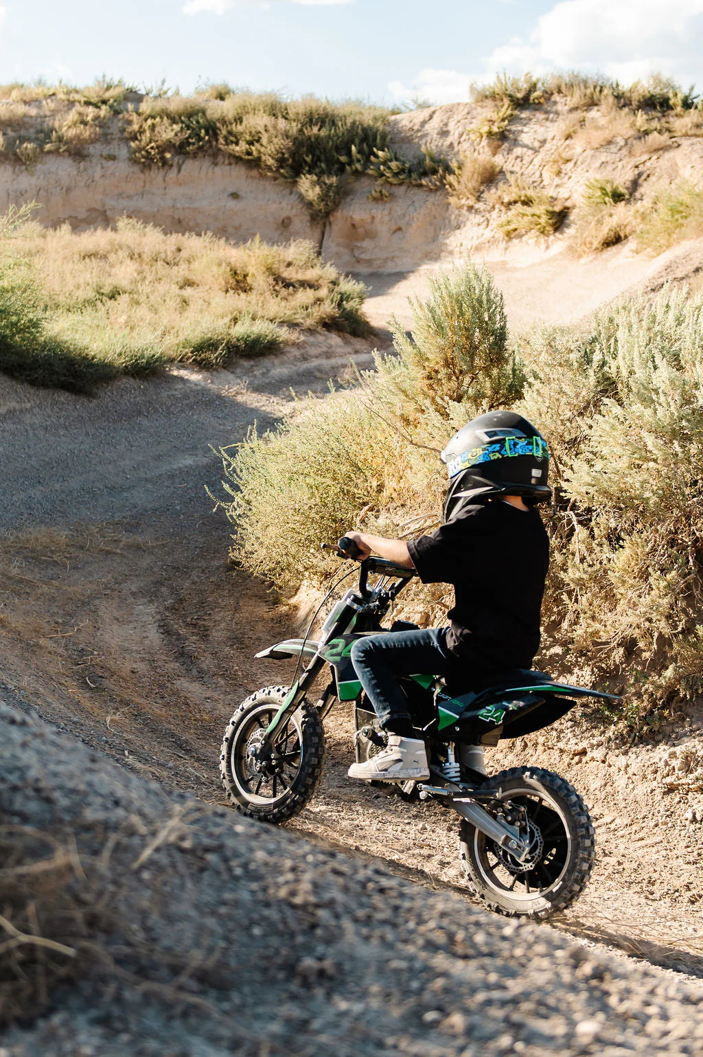 Child riding a Drift Hero USA 800W Electric dirt bike on a desert trail