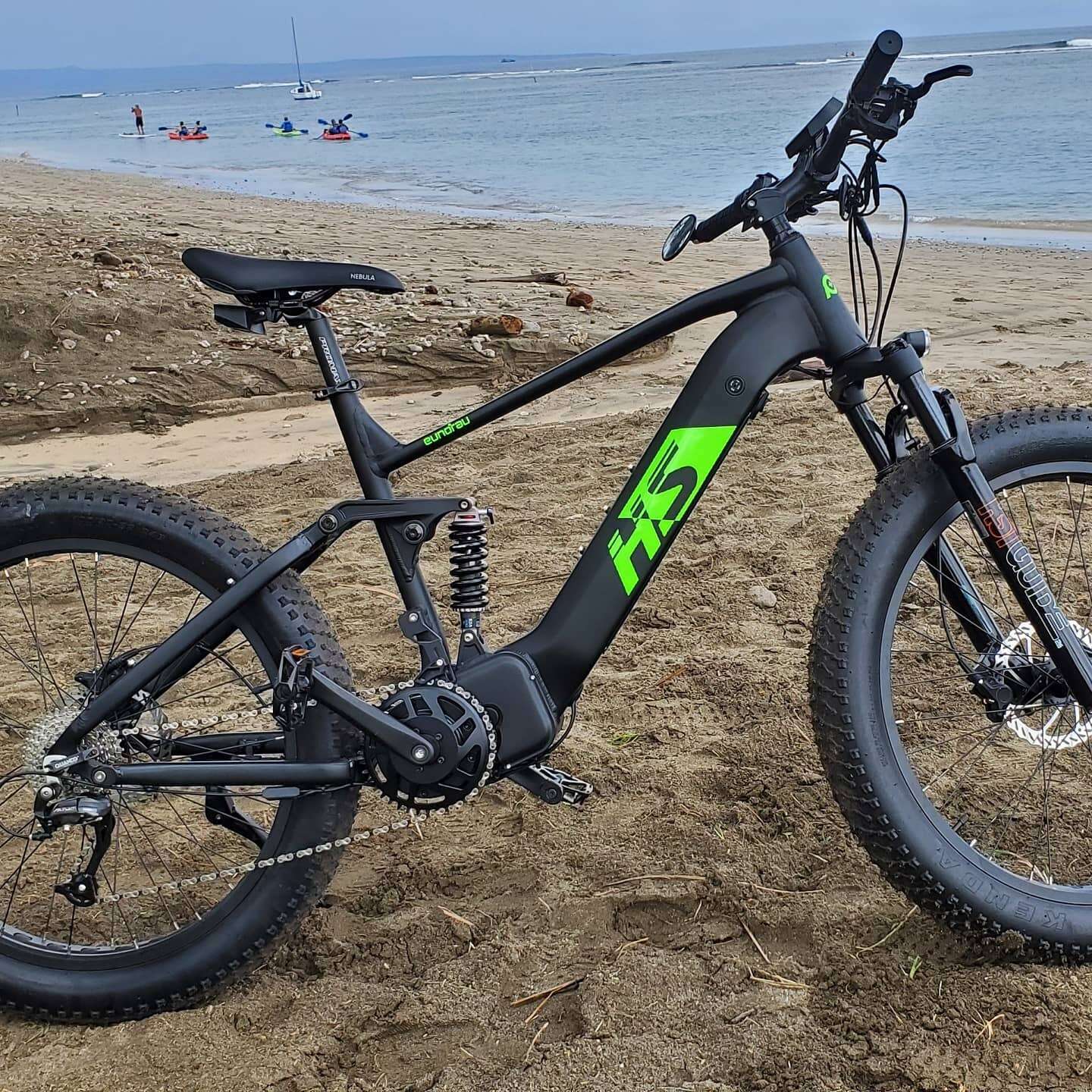 Eunorau Fat-HS 17 electric fat tire bike side profile view on the beach with full suspension and fat tires.
