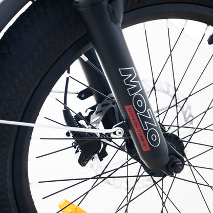 Close-up of a Eunorau G30 Cargo electric bike wheel with 'MOZO' branding on the suspension fork.