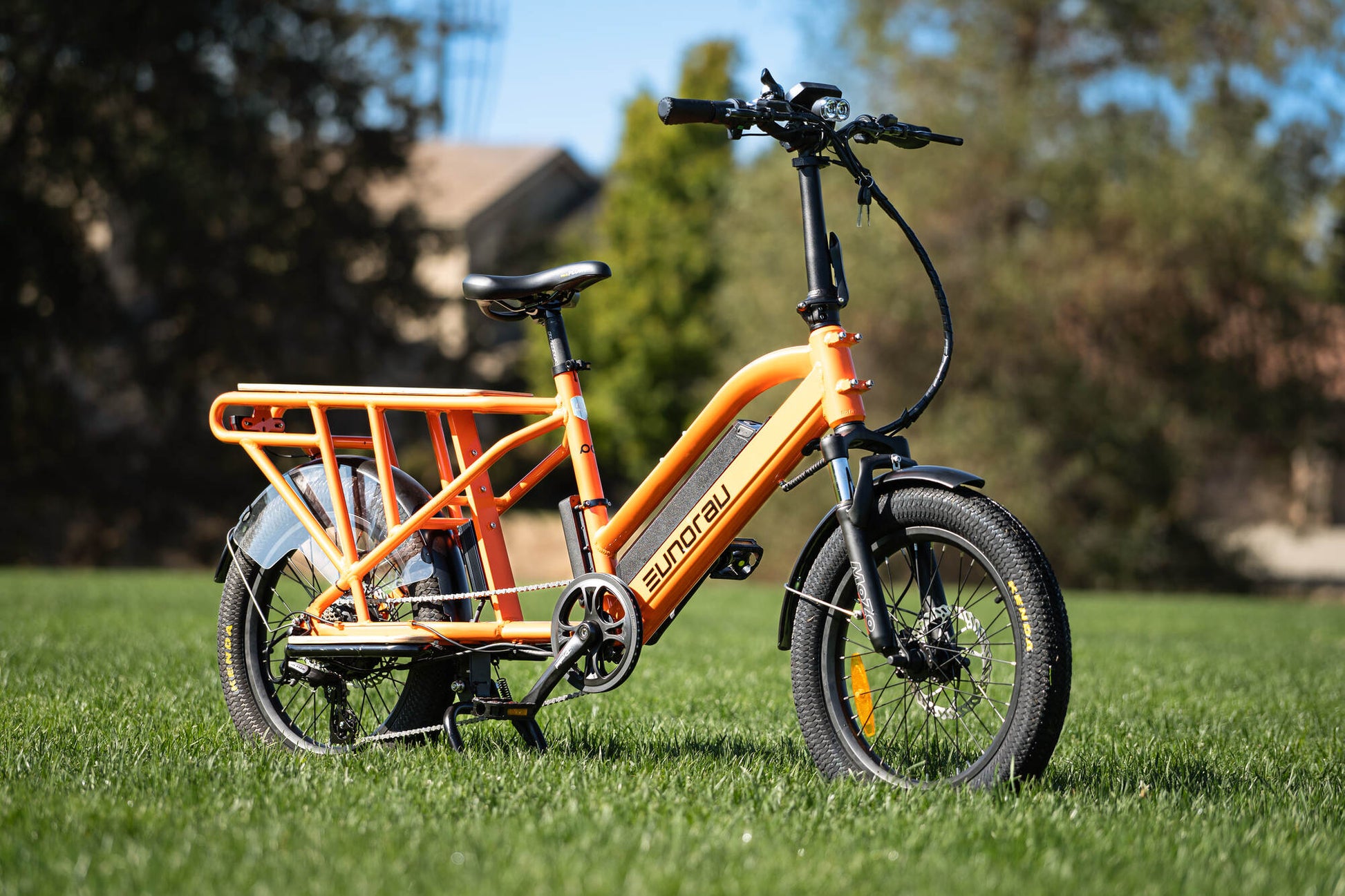 Orange Eunorau G30 Cargo electric bike with a basket on grass