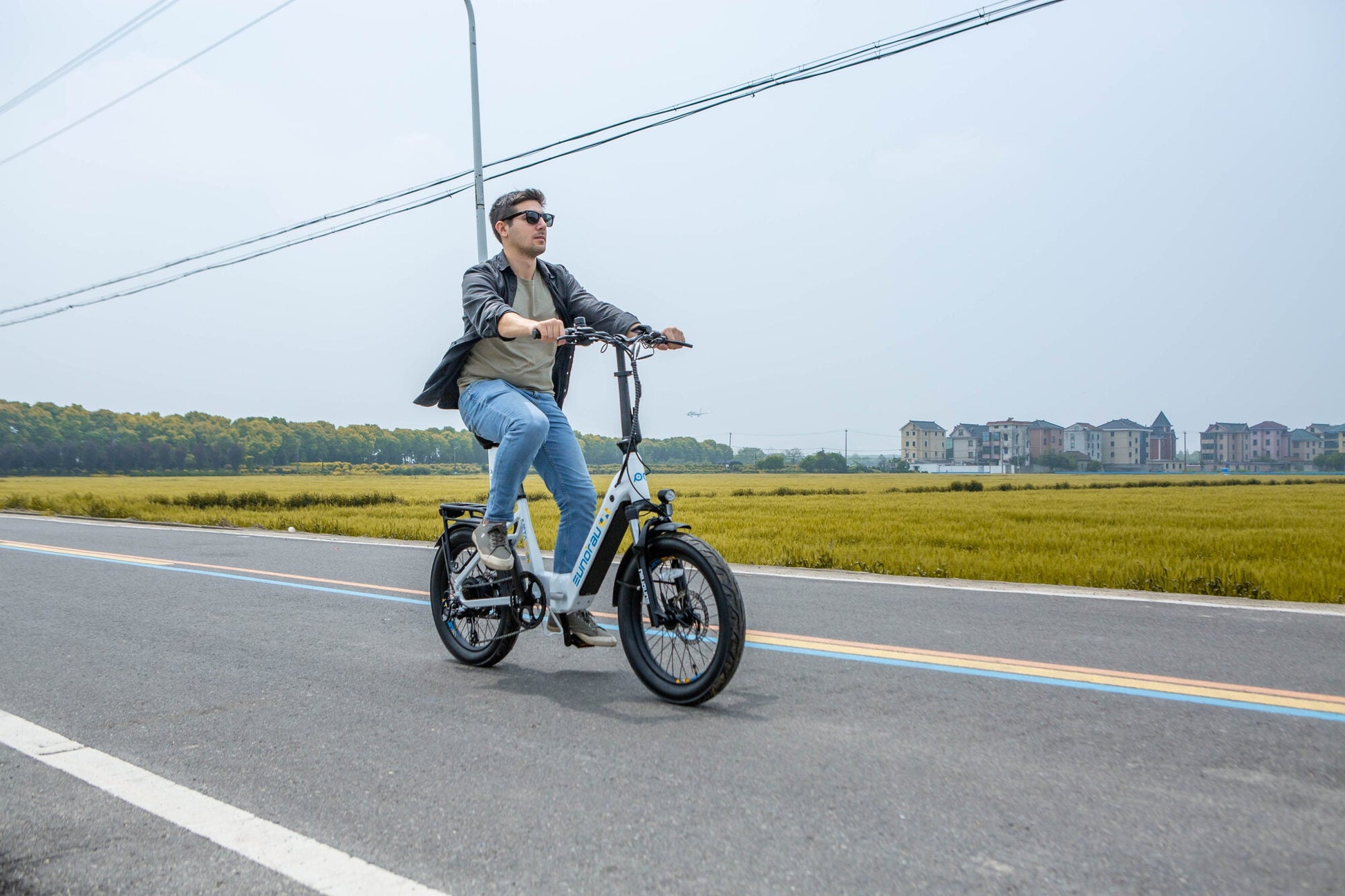 Man riding Eunorau Meta Foldable electric bike with 20-inch wheels on open road