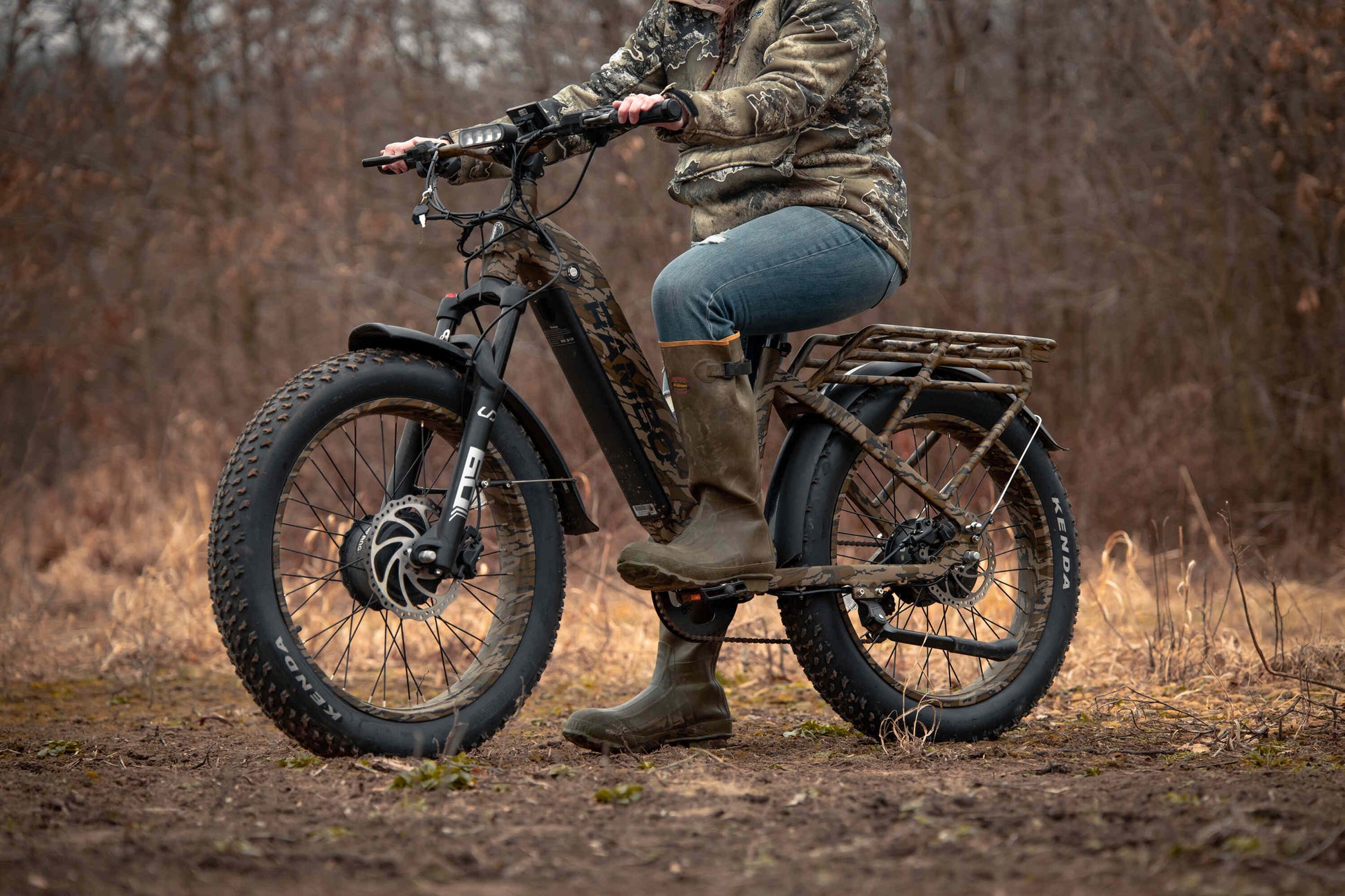Female rider driving a Rambo Bikes Krusader 3.0 All-wheel drive Electric Bike on a dirt trail in the forest
