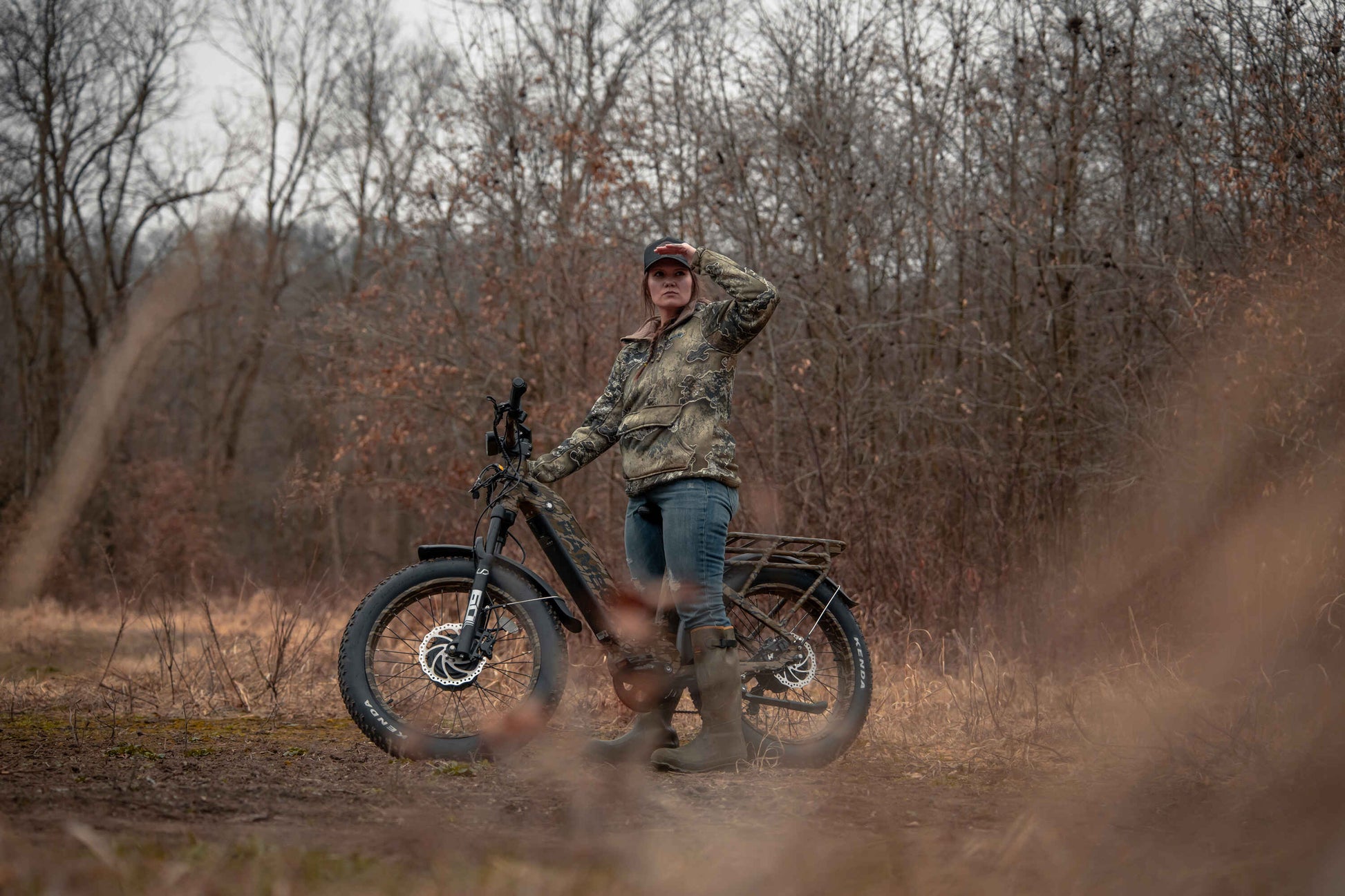 Female standing next to Rambo Bikes Krusader 3.0 All-wheel drive Electric Bike in forest with trees in the background