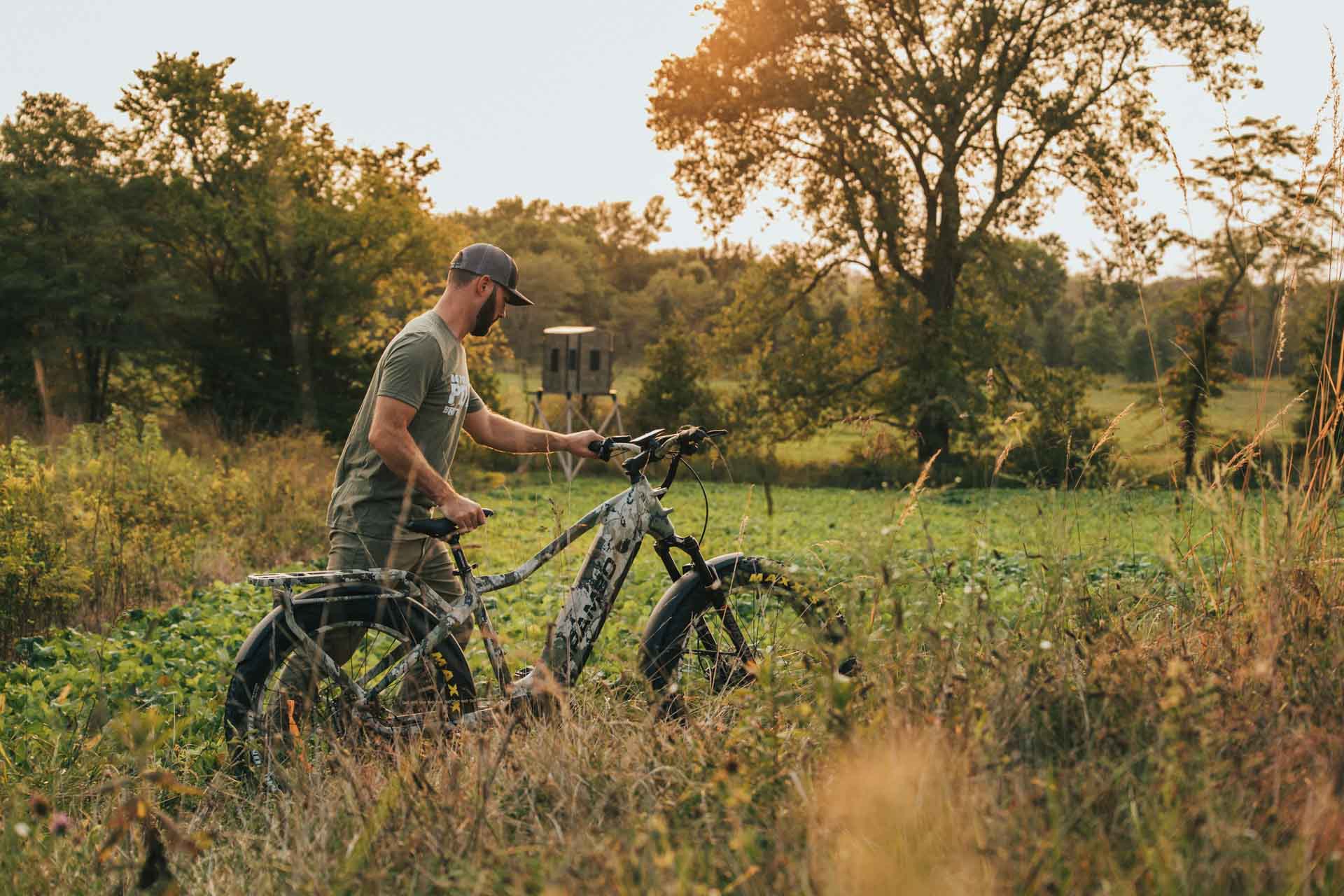Man with a Rambo Bikes Venom 2.0 Electric Bike in a field with trees in the background