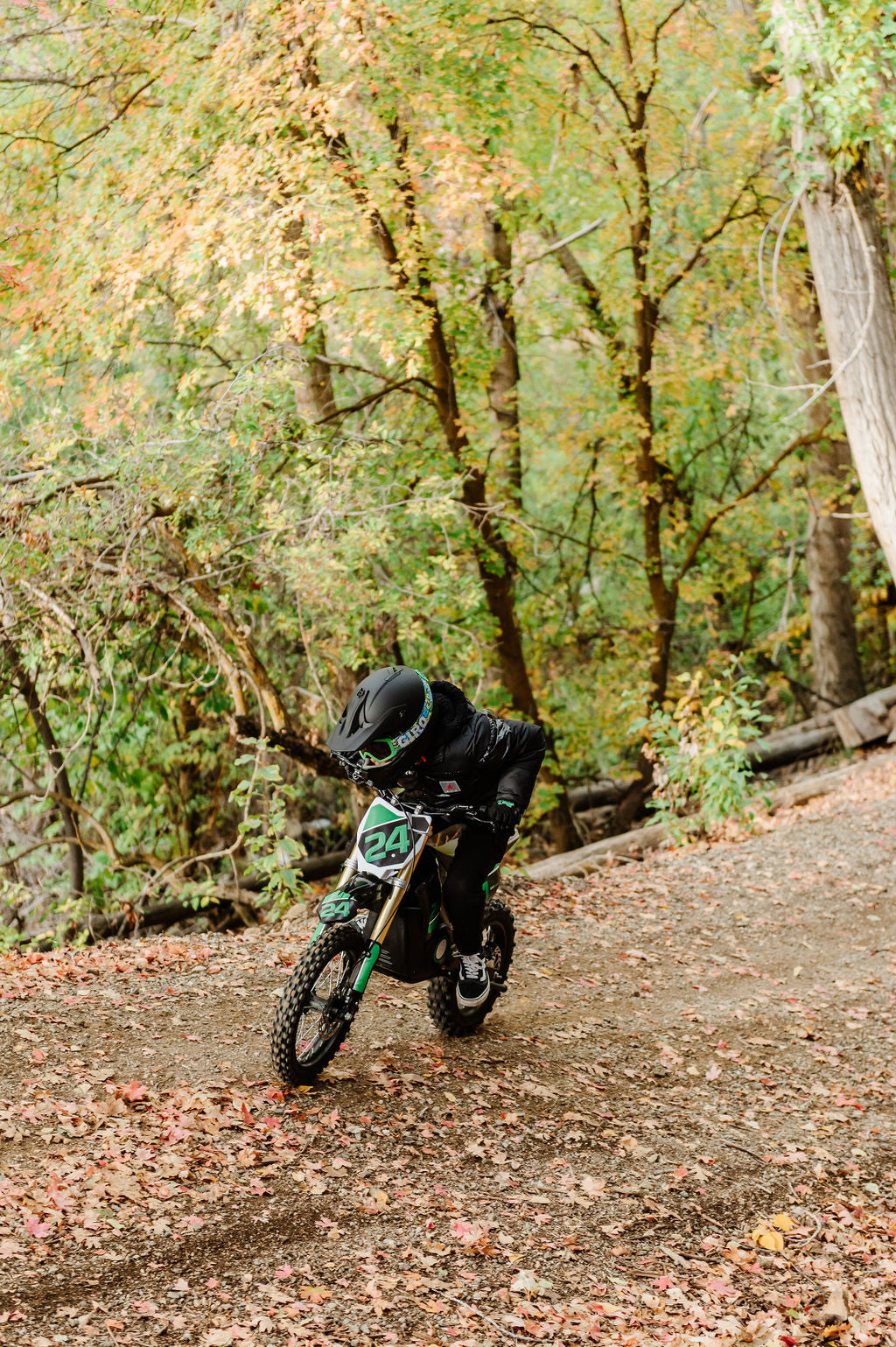 Person riding a Drift Hero USA 1600W Electric Dirt Bike on a trail with trees in the background