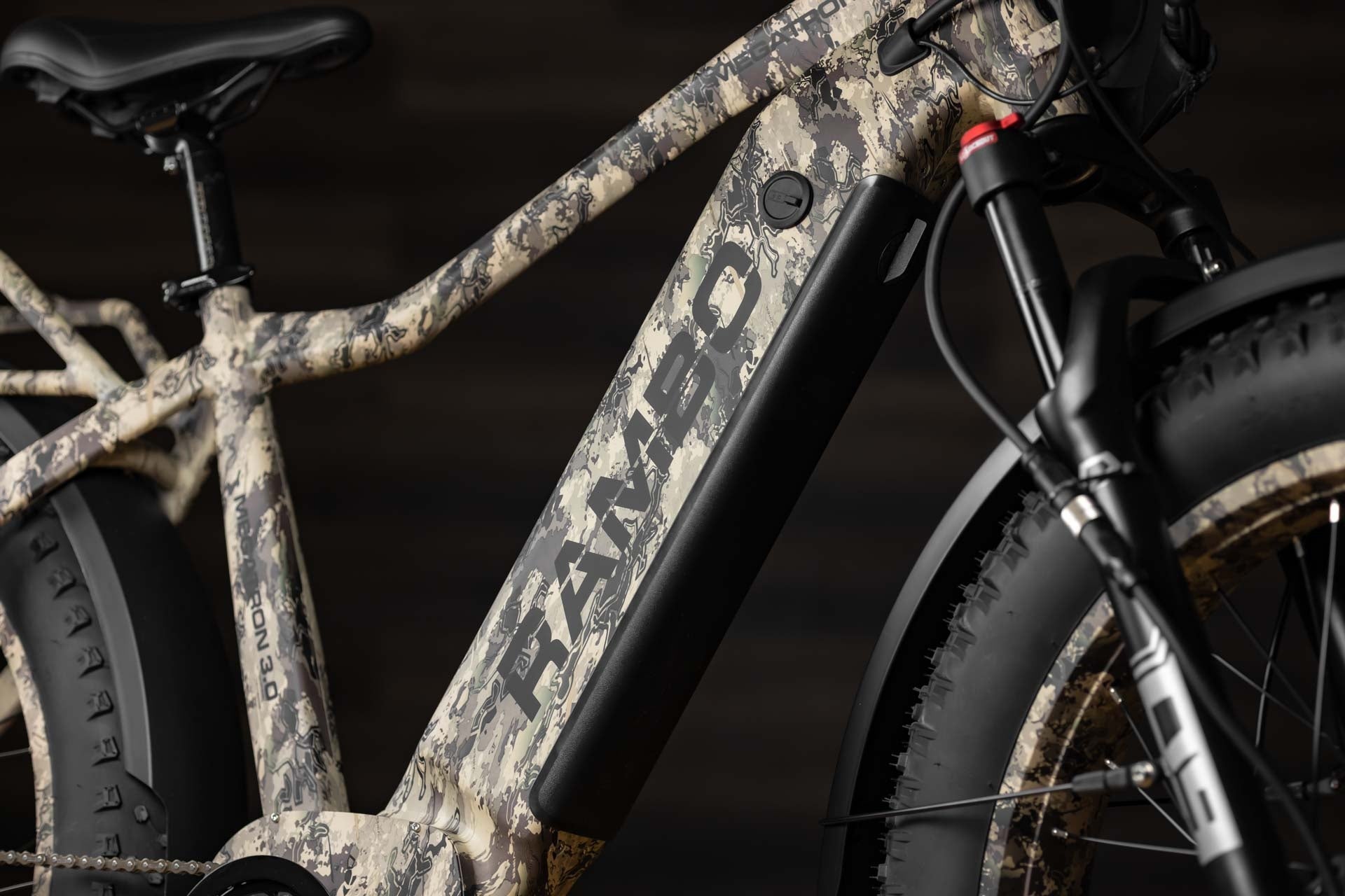 Close-up of a Rambo Bike Megatron 4.0 AWD Electric bike with a focus on the frame, front wheel and logo