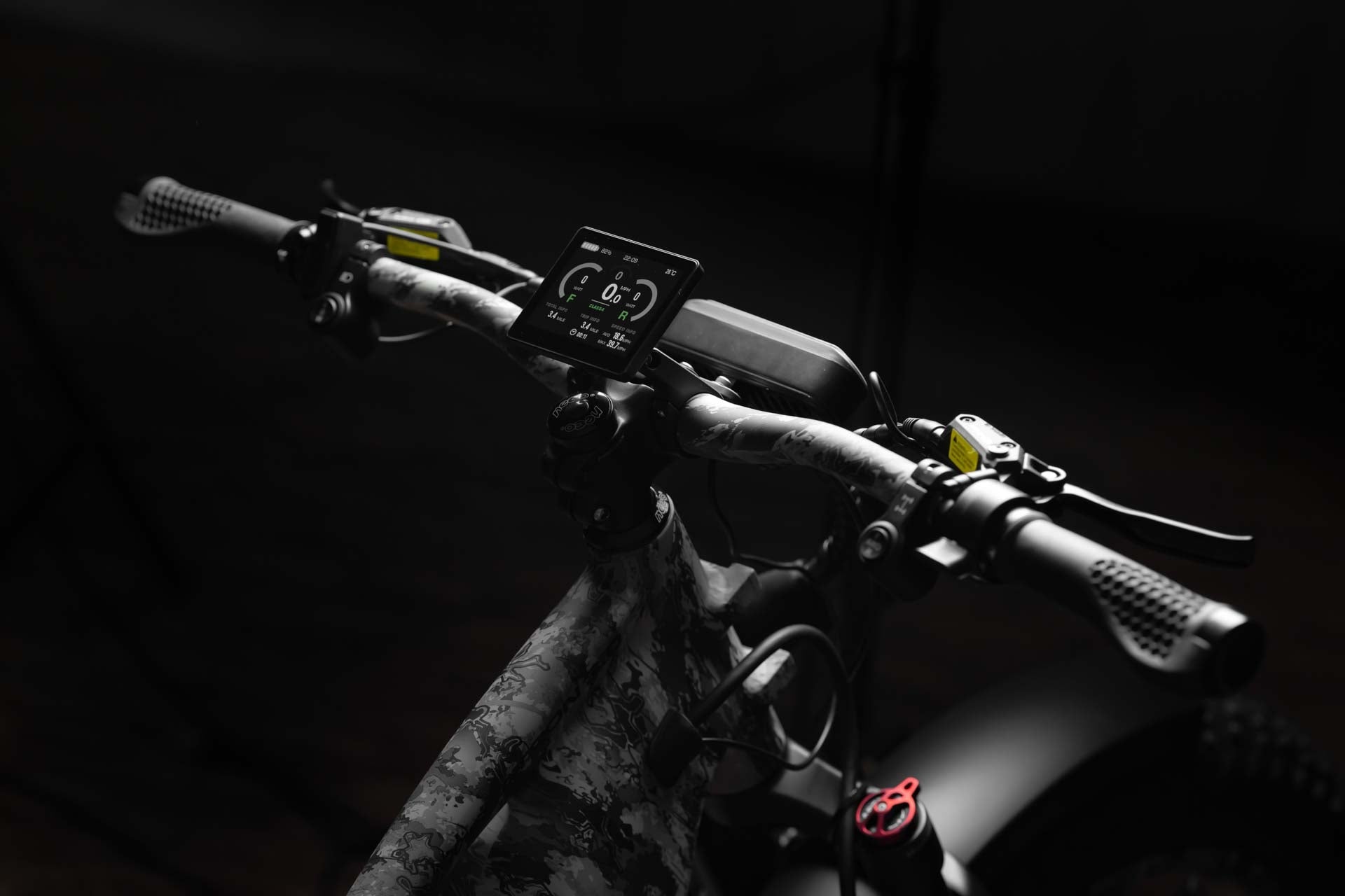 Close-up of a Rambo Bike Megatron 4.0 AWD Electric bike handlebar with digital display against a dark background