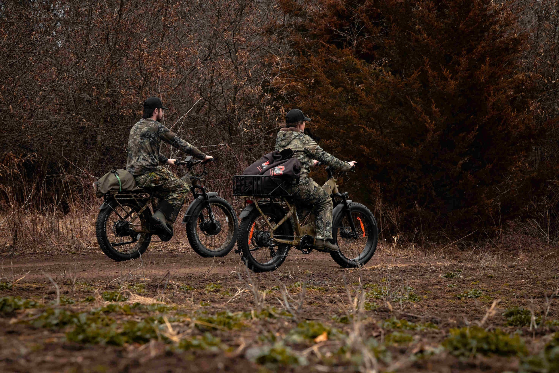 Two hunters in the forest riding a Rambo Bikes Krusader 3.0 All-wheel drive Electric Bike with trees in the background