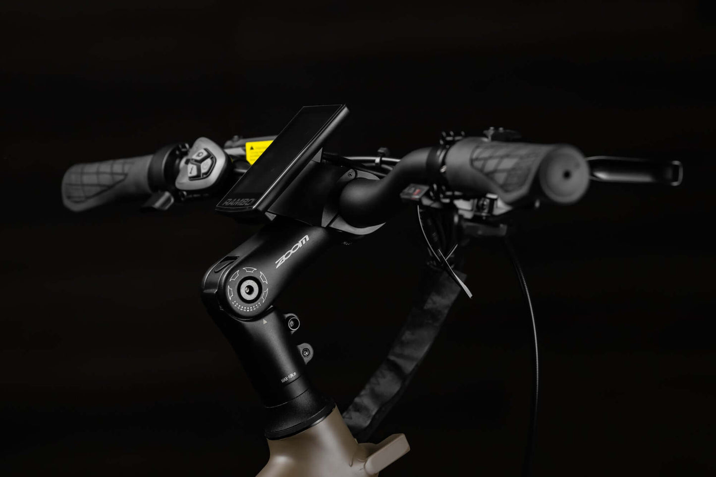 Close-up of Rambo Bikes SAVAGE 2.0 Electric Bikes handlebars with LCD screen, brake lever, control buttons, speed shifter on dark background
