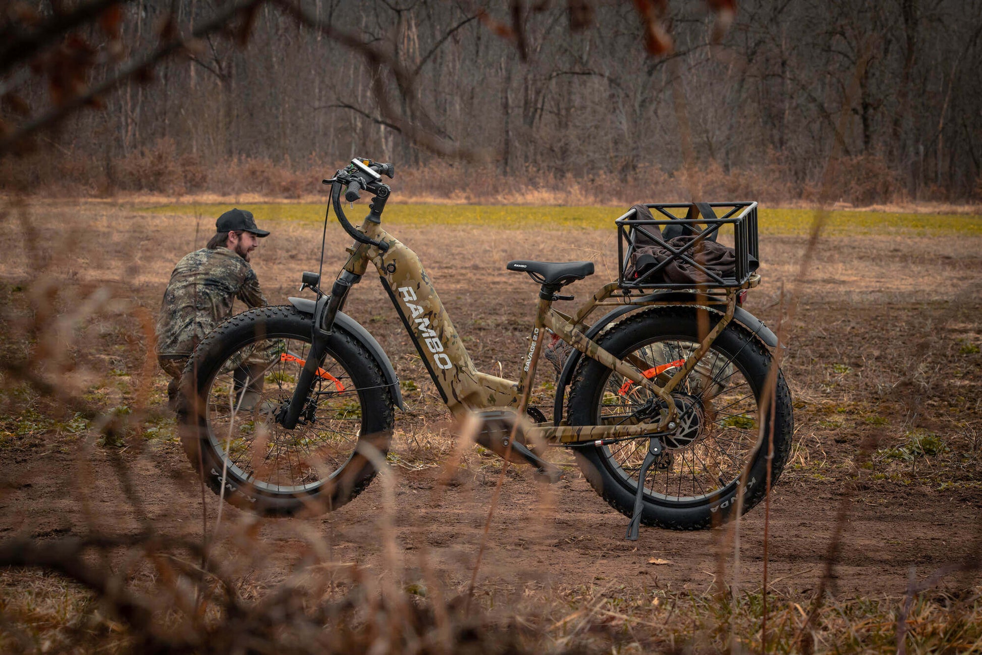 Person with a camouflage jacket and a Rambo Bikes SAVAGE 2.0 Electric Bike in a field