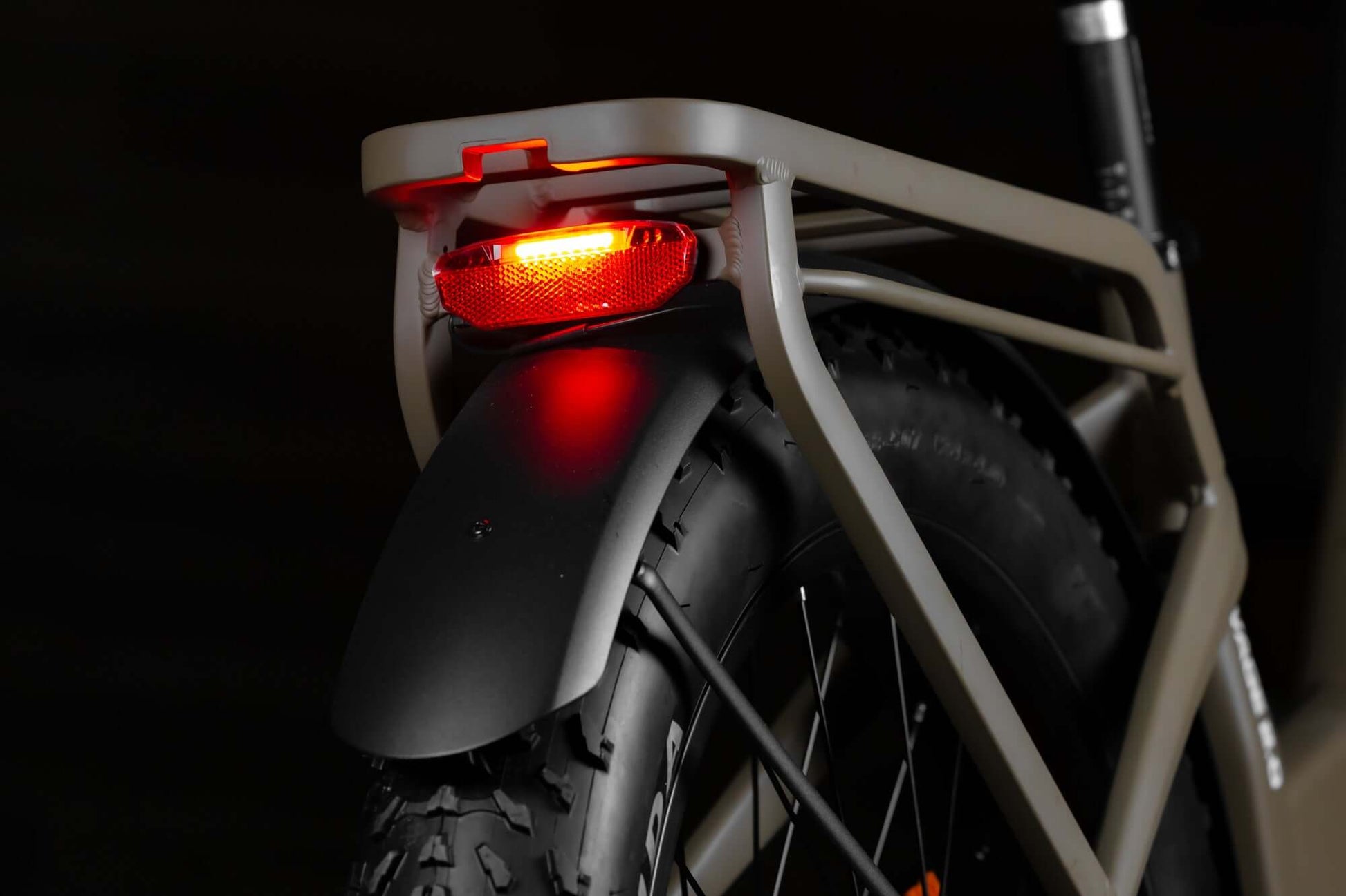 Close-up of Rambo Bikes SAVAGE 2.0 Electric Bikes rear wheel and rear rack on dark background