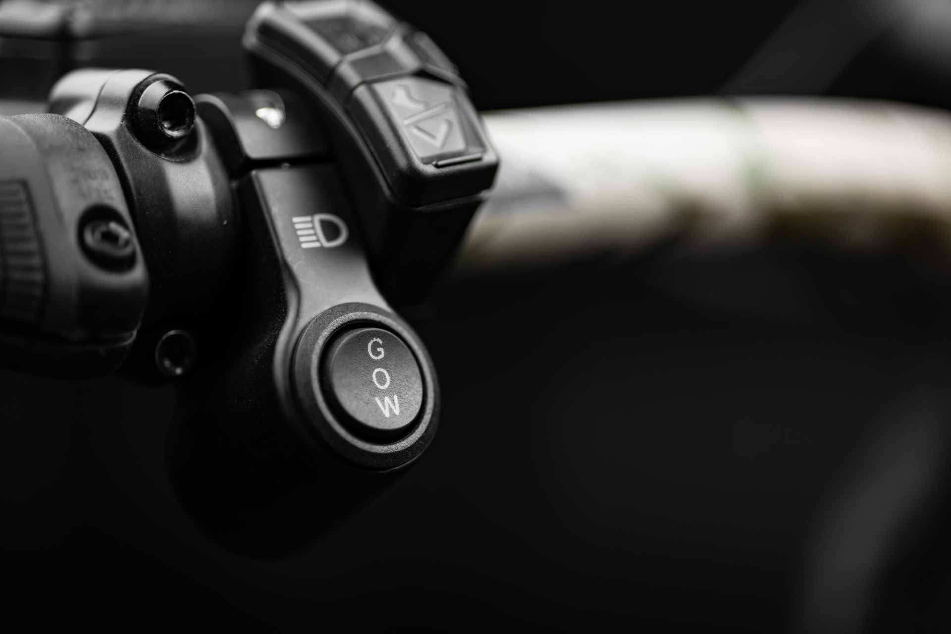 Close-up of a Rambo Bikes Venom 2.0 Electric Bike handlebar with control buttons on a blurred background