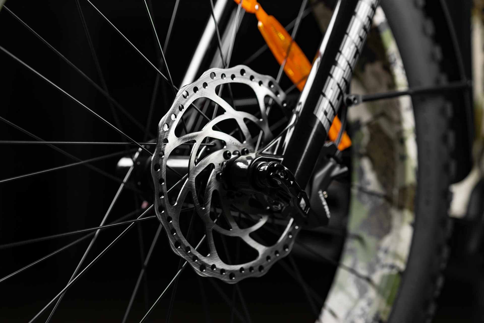 Close-up of a Rambo Bikes Venom 2.0 Electric Bikes disc brake rotor with orange reflector