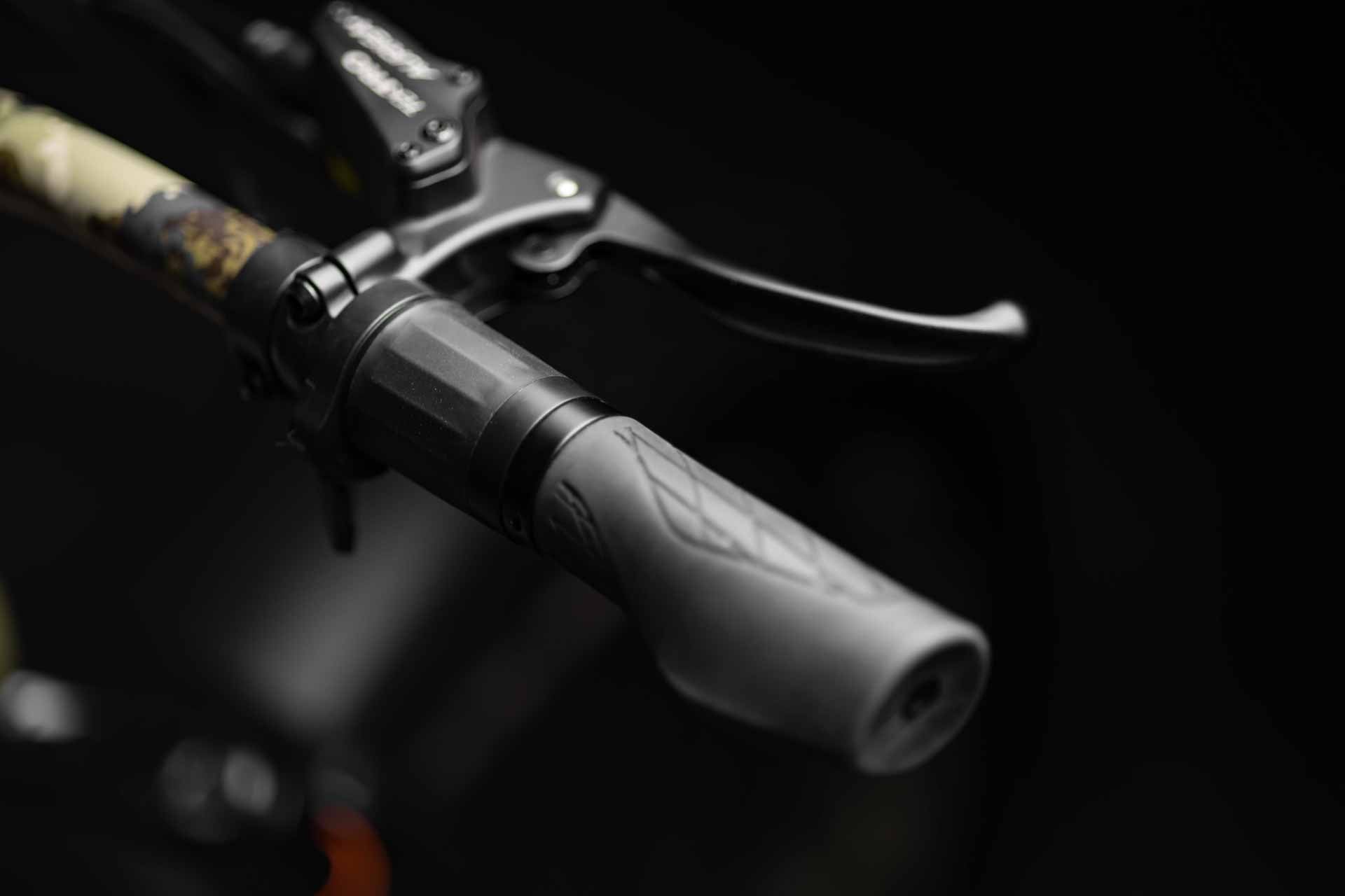 Close-up of Rambo Bikes Venom 2.0 Electric Bikes right handlebar with throttle and brake lever on dark background